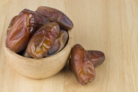dried dates in the bowl on the wood table.の写真素材