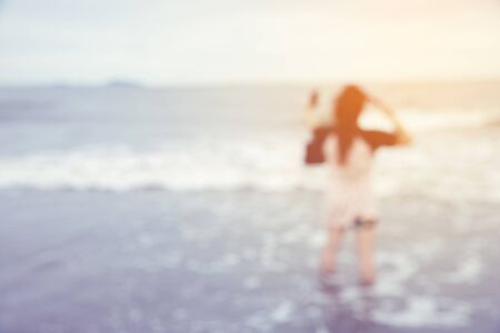 Blurred background of woman on the beach - vintage filterの写真素材