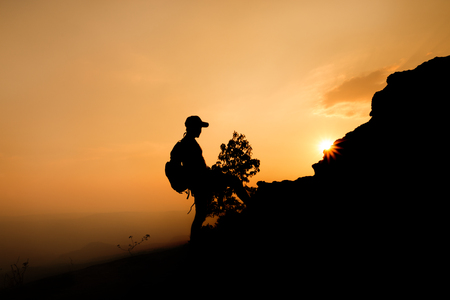 silhouette of a man hiker on the top of the hillの写真素材