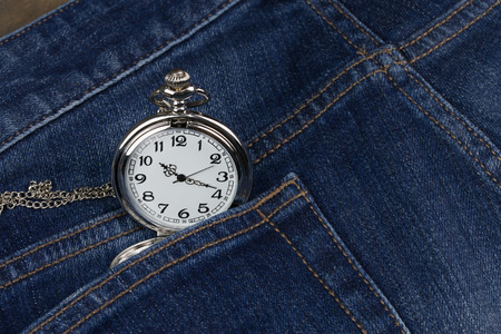 pocket watch on blue jeans