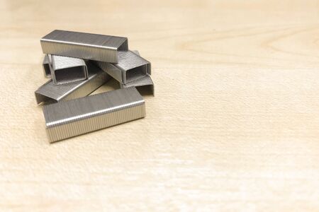 metal staples on wooden table.