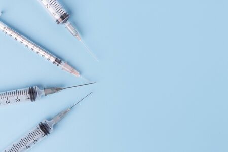 Close-up of medical syringe on blue background. Top view with copy space.の写真素材