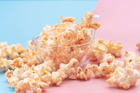 Popcorn in a bowl on blue and pink background.の写真素材