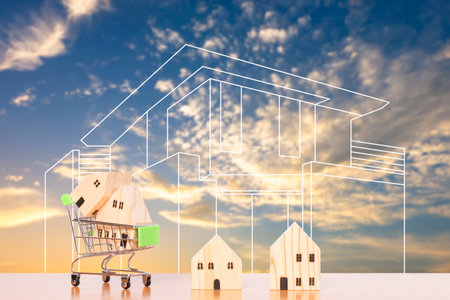house model in shopping cart and sketch of home with evening sky background.の写真素材