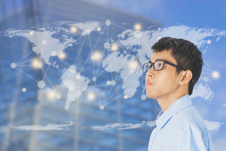 Businessman standing on and looking copy space at office buildings with world map and connected link, The concept of modern life. business. with copy space for text.の写真素材