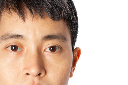 Closeup of face young Asian man on white background.の写真素材