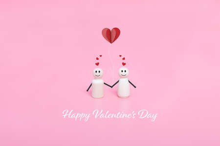 Valentine's day. Couples of wooden doll and hearts shape in pink background. Holiday banner, greeting card.の写真素材