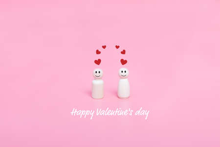 Valentine's day. Couples of wooden doll and hearts shape in pink background. Holiday banner, greeting card.の写真素材