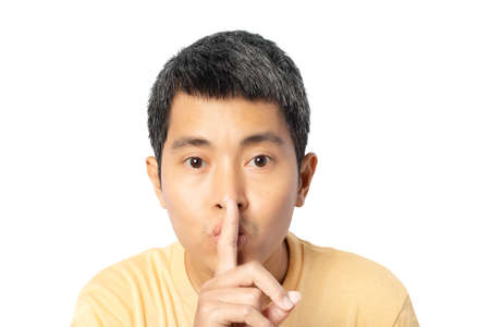 Young man making hush gesture and keep conspiracy isolated on white background. clipping paths....
