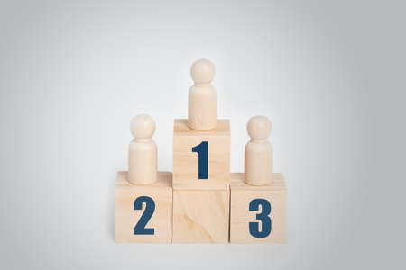 Wooden doll standing on podium 1, 2, 3 of wooden building blocks, Business hierarchy, ranking and strategy concept.の写真素材