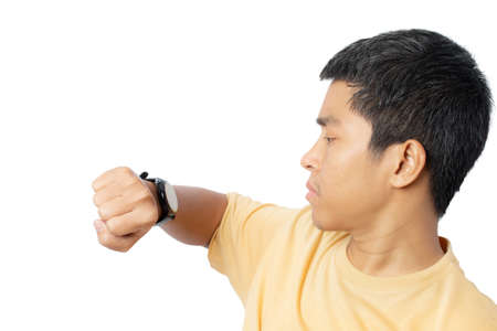 Portrait of a young man looking at wristwatch isolated on white background.clipping paths.の写真素材