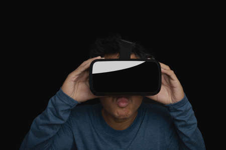 Young man using virtual reality headset. VR, future, technology online concept. dark background.の写真素材