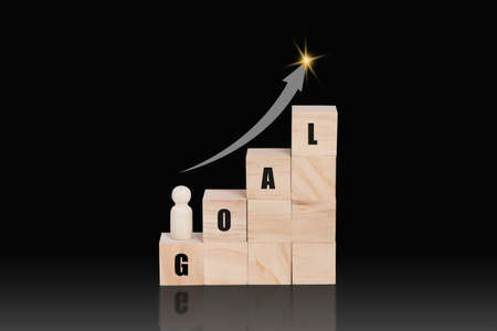 Wooden block stacking as a growth on top with word GOAL and arrow up. Business growth concept.の写真素材
