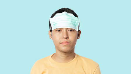 Young man wearing medical mask wrong. Wearing a medical mask won't protect