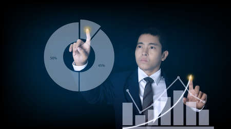 Businessman pointing spot on the graph finance chart. Digital business hologram graph finance chart background. For the business and finance concept.の写真素材