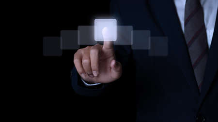 Businessman hand pushing on a touch screen interface. Choice concept.