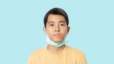 Young man wearing medical mask wrong. Wearing a medical mask won't protectの写真素材