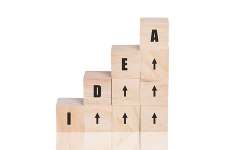arranging wood cube stacking as step stair with idea text and arrow up symbol. Business concept...