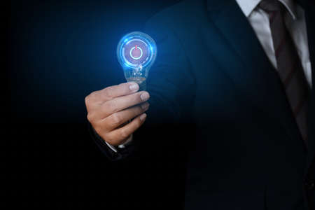 Businessman holding glowing light bulb with power button symbol. innovation concept.