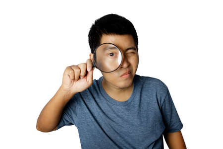 Young man with magnifying glass isolated on white background.の写真素材