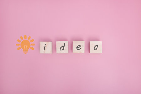 Arranging wood cube with idea text on pink background with free text space.の写真素材