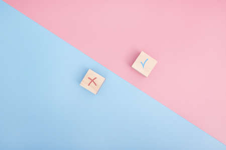 True and false icon accepted rejected, Yes or No on wood cubes. pink and blue background.の写真素材