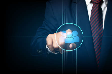 Businessman touching screen, pushing on a icon connected together. Cooperation, teamwork, network and community concept.の写真素材
