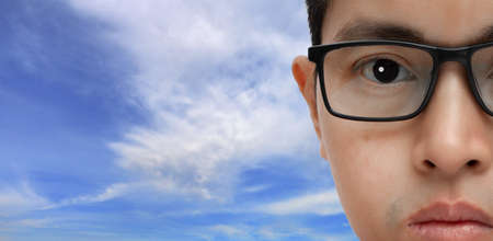 Portrait of a young man wearing eyeglasses with bleue sky background. copy space.