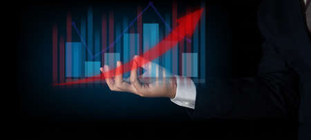 Businessman holding graph finance chart. Digital business hologram graph finance chart background. For the business and finance concept.の写真素材