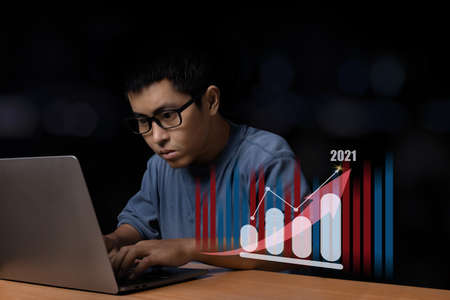 Young man with eye glasses browsing at his computer laptop with a growing graph and arrow up,...