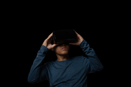Young man using virtual reality headset. VR, future, technology online concept. black background.の写真素材