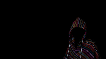 Scary and creepy man hiding in the shadows, with the face and identity hidden with the hood, Dark...