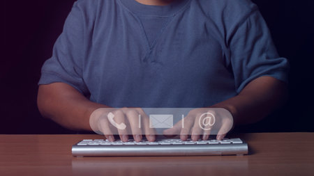 Businessman using computer keyboard with icon call phone, email and address. Customer support service contact us people connection concept.の写真素材