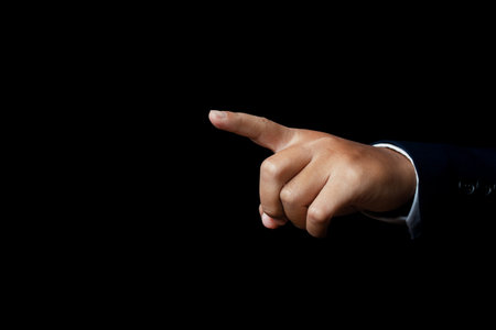 Hand finger pointing isolated on black background. copy space.
