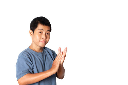 Portrait of young  wearing casual t-shirt applauding. congratulation and clapping hands and presentation concept. studio shot isolated on white background.の写真素材