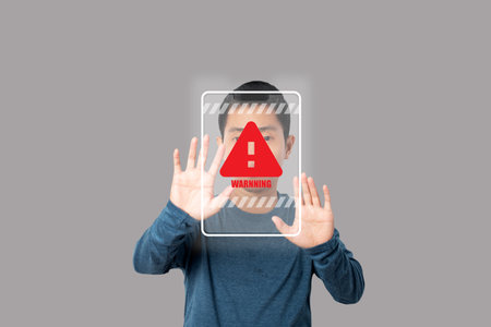Young man showing stop gesture with warning sign virtual screen. Warning and alert attention signs. Caution futuristic design elements in modern technology style.の写真素材