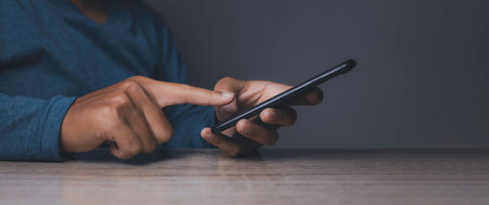 Young man using smartphone. Hand holding mobile texting message contact us.chatting,search internet information. Technology device communication connecting.の写真素材