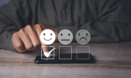 Customer satisfaction experience concept. Businessman choosing  happy smiley face icon to give satisfaction in service. rating very impressed. copy space.の写真素材