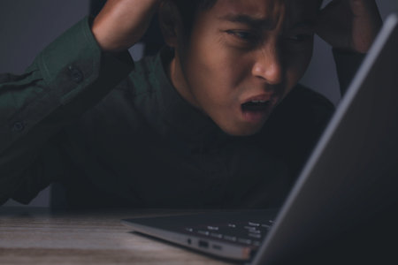 Businessman working on laptop of a feeling disappointed from mistake in business situation.の写真素材