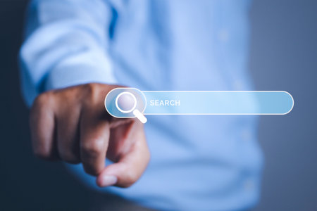 Searching browsing internet data information networking concept. Search Engine Optimization SEO Networking. Man hand presses the information search button on search bar virtual screen, copy space.の写真素材