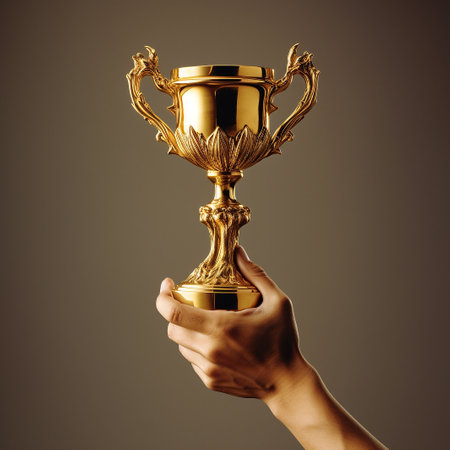Hand of businessman rise and holding golden trophy.の素材