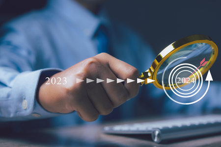 Businessman using magnifying glass management target in 2024. Business success.の写真素材