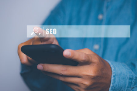 Businessman using smartphone to optimize online content with SEO tool with search bar.の写真素材