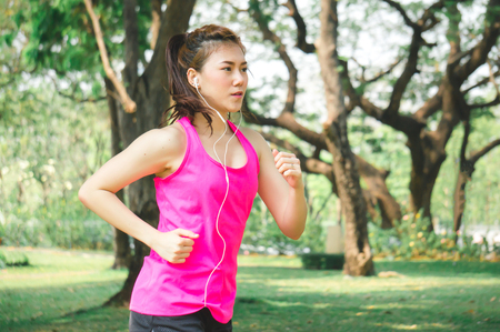 Asian sport woman running / jogging in park for healthの写真素材