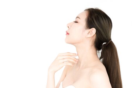 Beauty Asian woman touch body to present product for skin on white backgroundの写真素材