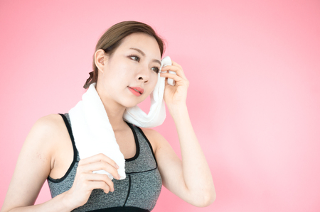 Asian beauty woman in sport bra with white towel for exercise on pink backgroundの写真素材