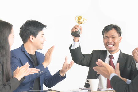 Businessman get award trophy for achievement with successful teamの写真素材