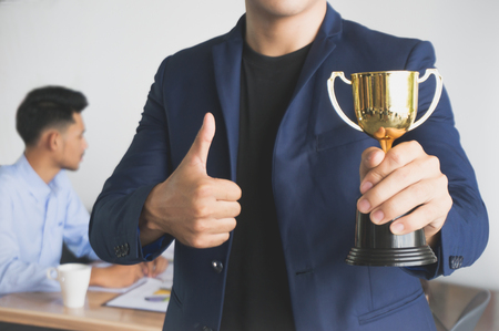 Businessman show award trophy with successful and achievementの写真素材