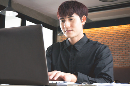 Businessman working in coffee shop are typing laptopの写真素材