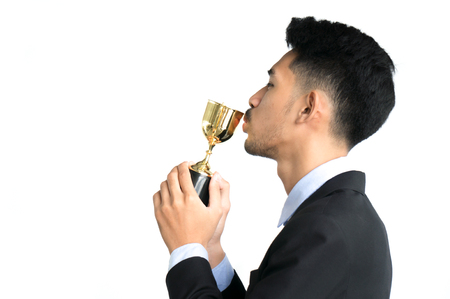 Businessman as winner kiss trophy award isolated on white backgroundの写真素材